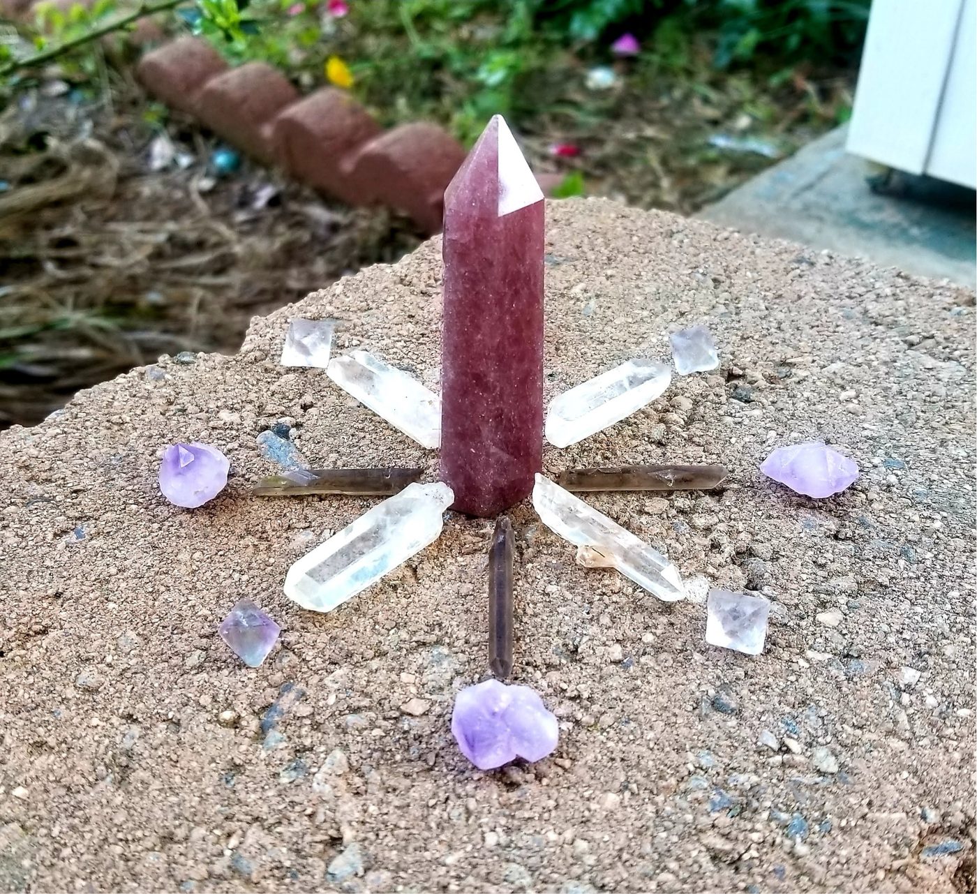 A real crystal grid built with a rhodonite point, clear quartz, and amethyst for energy work
